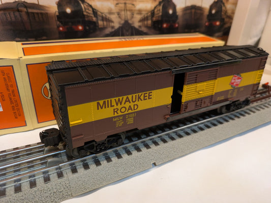 Lionel 6-52126 Milwaukee Road boxcar three-quarter view with sliding door open and original box, brown and yellow