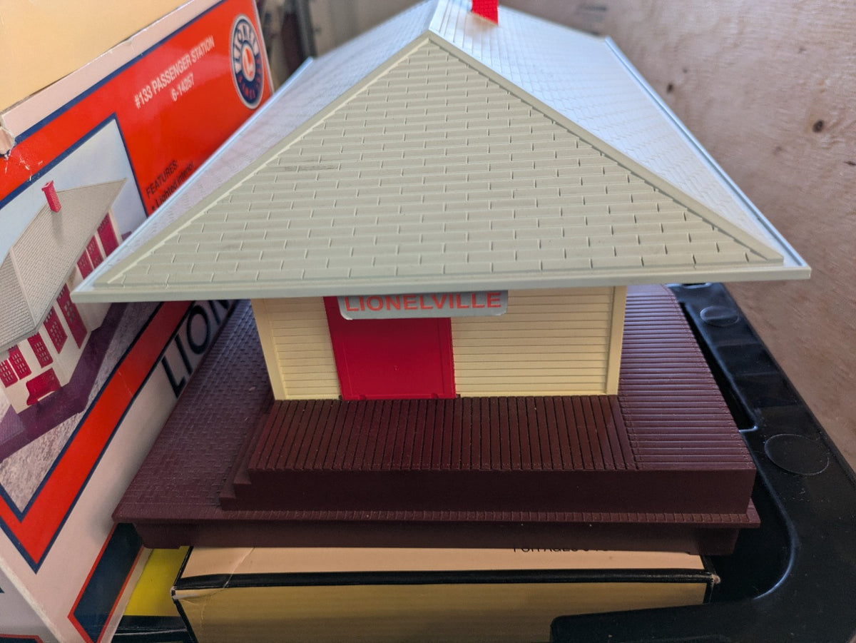 Lionel 6-14257 #133 Passenger Station front three-quarter view with cream walls, red doors, gray roof, and brown base