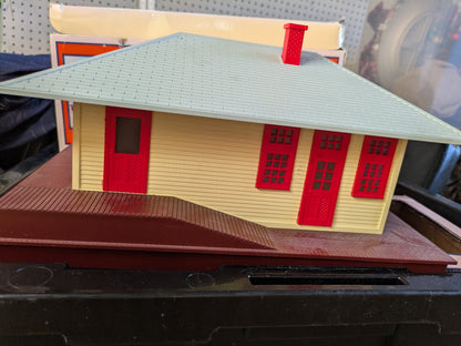Lionel 6-14257 #133 Passenger Station side view with cream walls, red doors and windows, gray roof, red chimney, and brown base