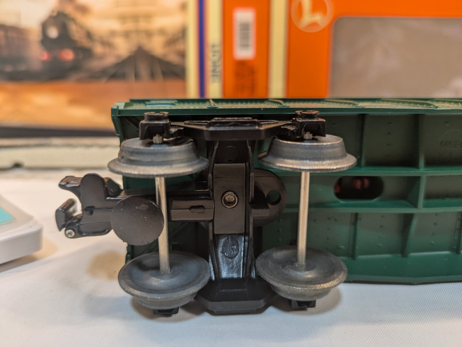 Lionel 6-16795 underside close-up showing operating coupler, black truck, and metal wheels and axles