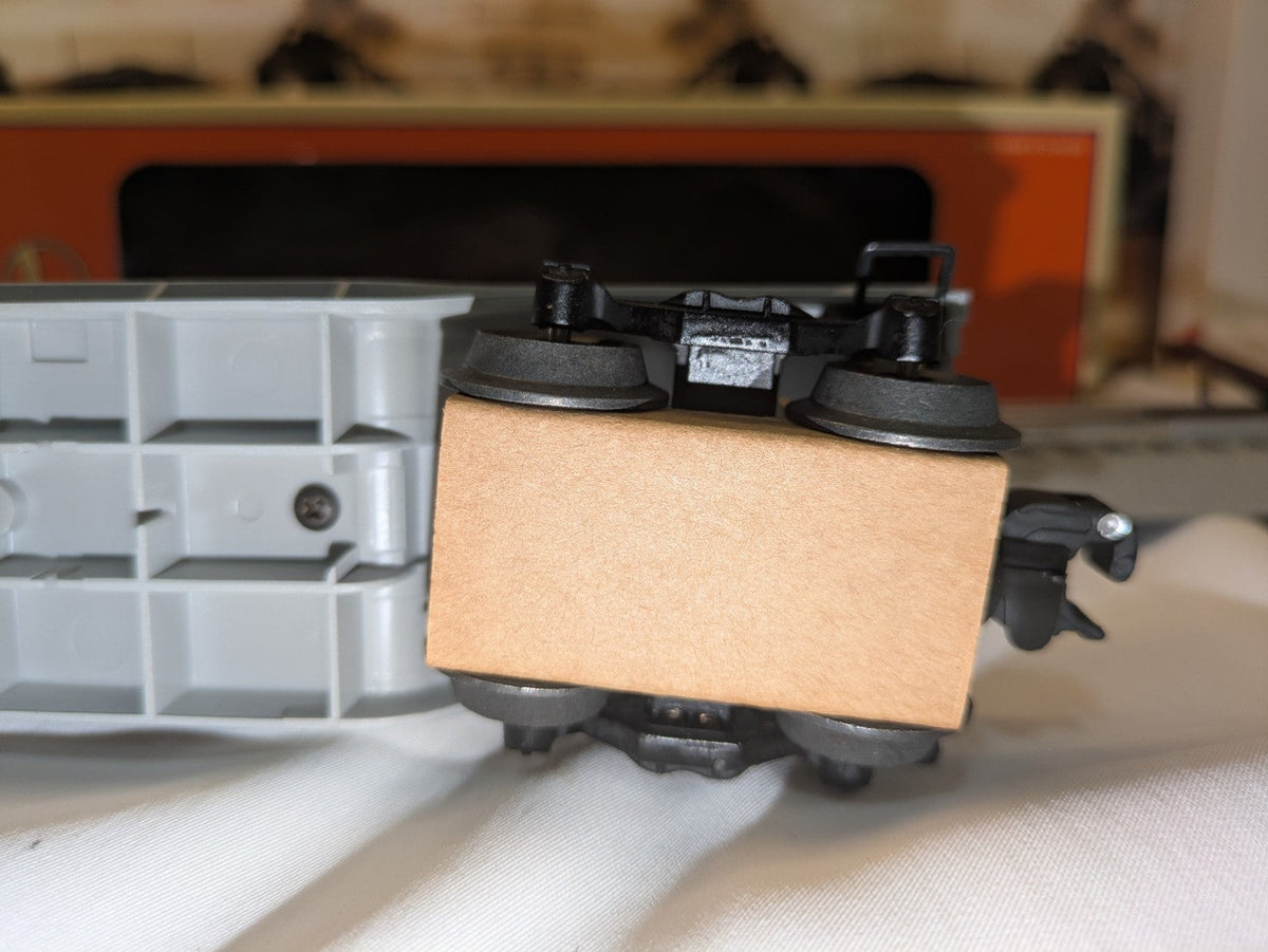 Lionel 6-16967 underside detail showing truck, wheelsets, coupler, and cardboard packing block