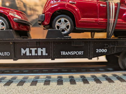 MTH 30-76039 black flatcar side detail with M.T.H. Transport 2000 lettering and red PT Cruiser