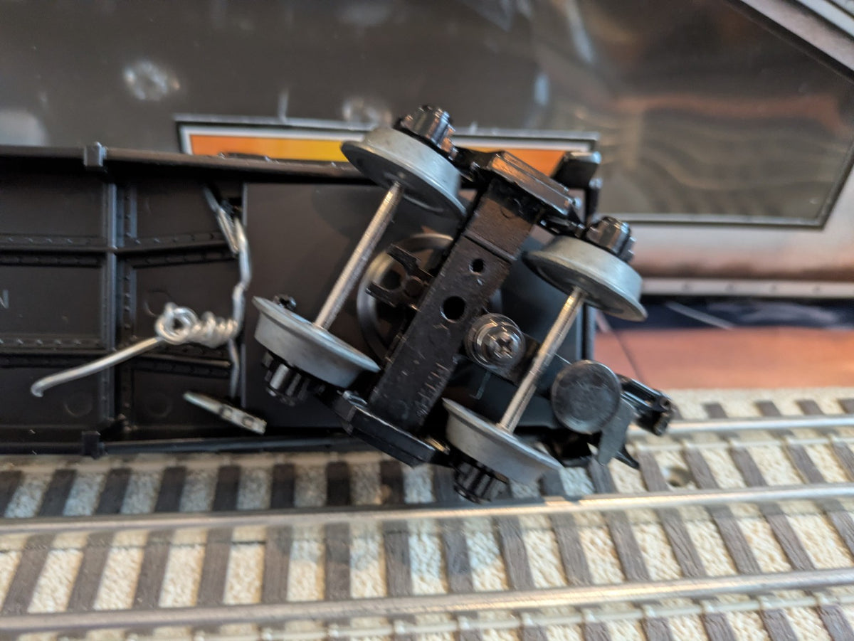 MTH 30-8304 black flatcar underside with metal trucks and coupler, angled view