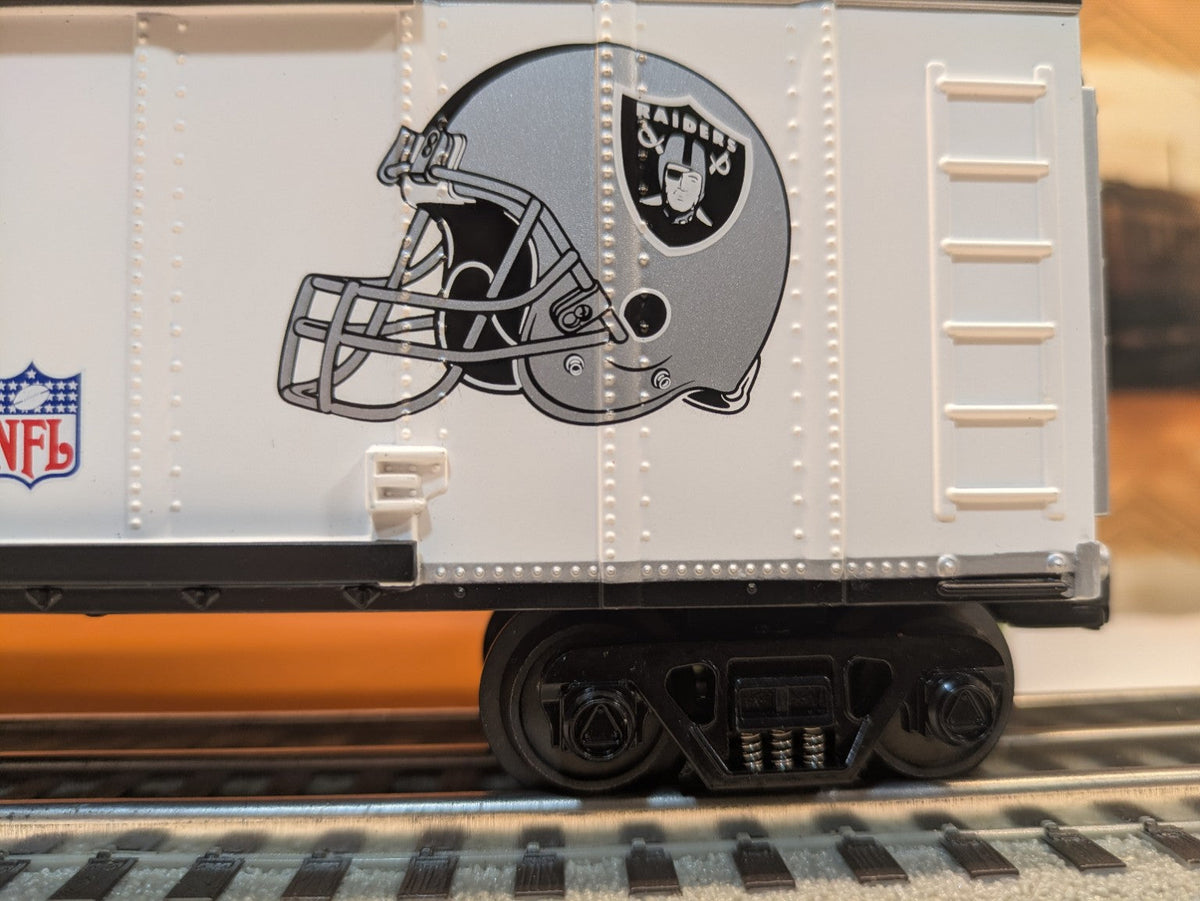MTH Rail King 30-74265 Oakland Raiders boxcar, side close-up of Raiders helmet graphic, NFL shield and black truck