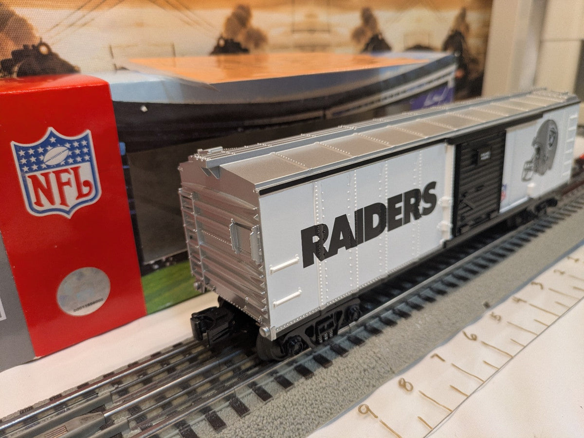 MTH Rail King 30-74265 Oakland Raiders boxcar, three-quarter silver and white side view with NFL-branded box behind