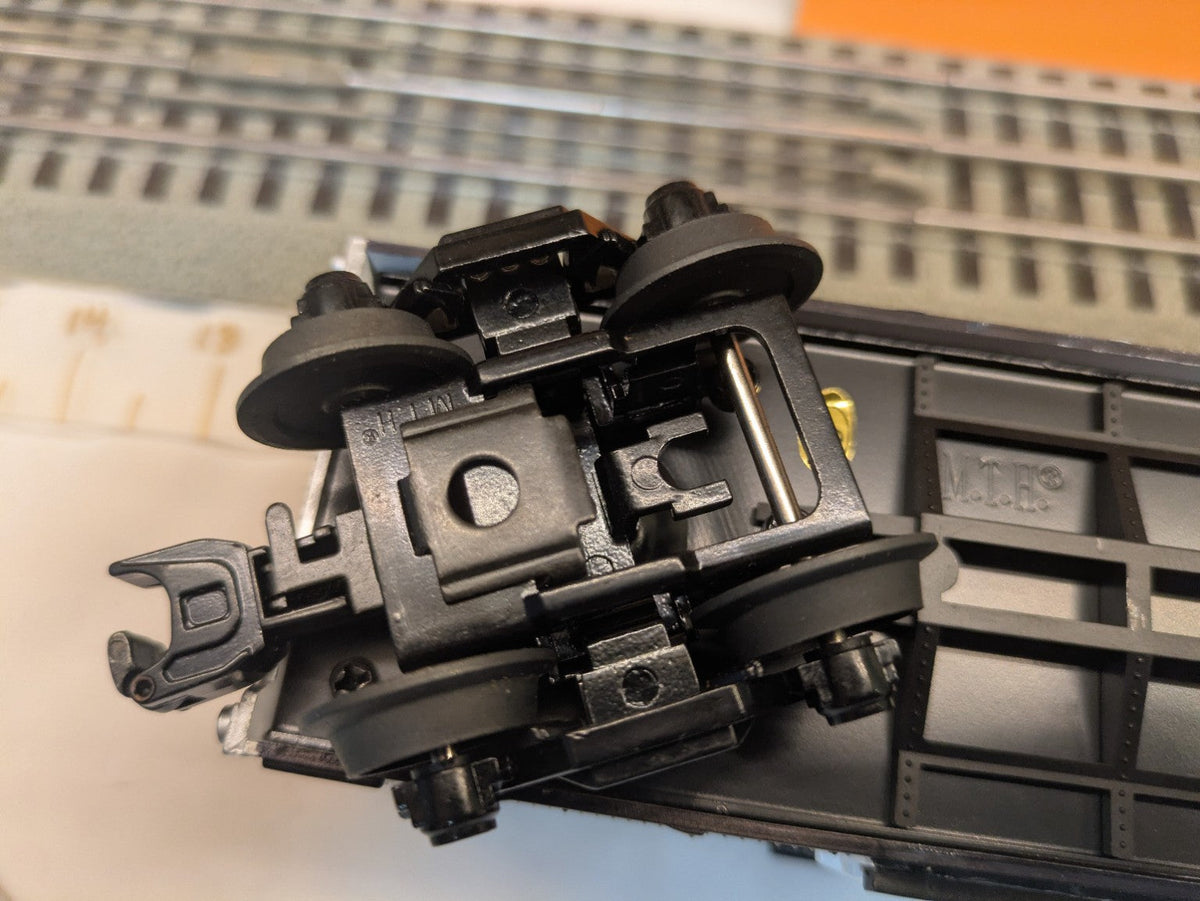 MTH Rail King 30-74265 Oakland Raiders boxcar, opposite-angle underside close-up of black truck, wheels and coupler